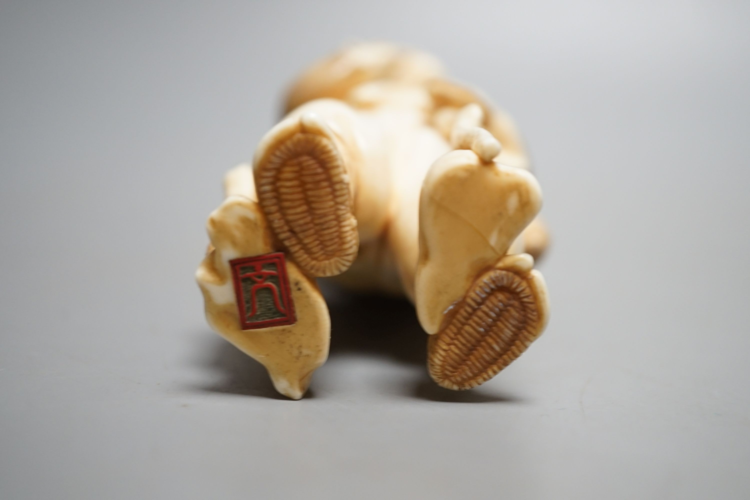 A Japanese ivory figure of a farmer smoking a pipe, Meiji period, signed - 12cm tall